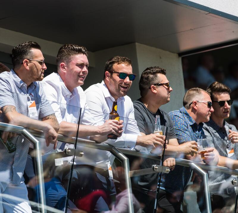 A group of guys enjoying the hospitality balcony at Bath Racecourse